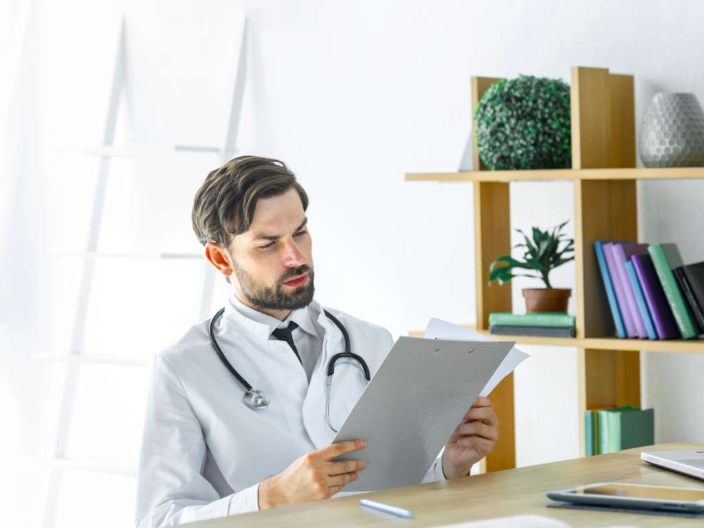 Médico revisando historia clínica durante examen ocupacional según la Resolución 1843 de 2025