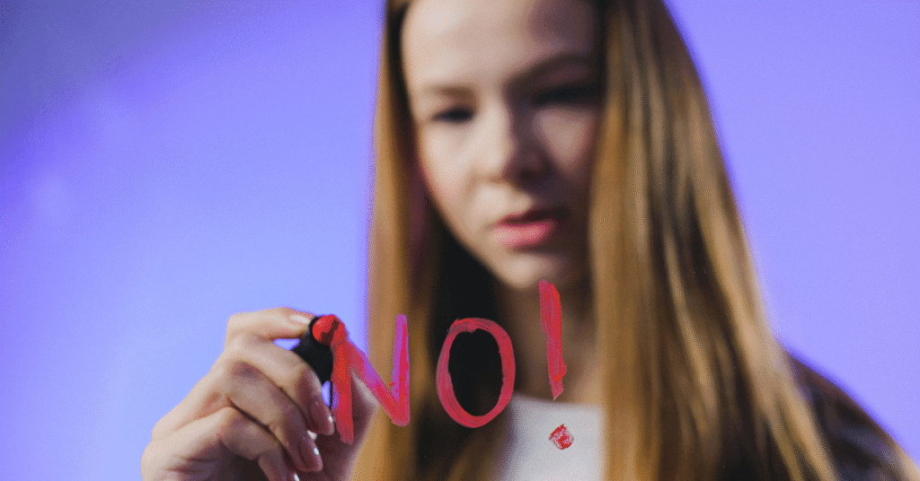 Mujer joven escribe la palabra “NO” en un vidrio, simbolizando la eliminación del concepto “No Apto” en exámenes ocupacionales según la Resolución 1843 de 2025.