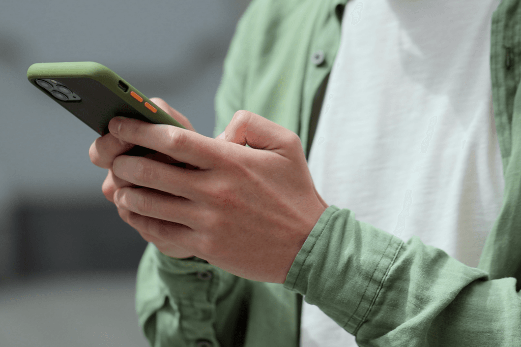 Persona usando celular para solicitar examen ocupacional en Forjar Salud.