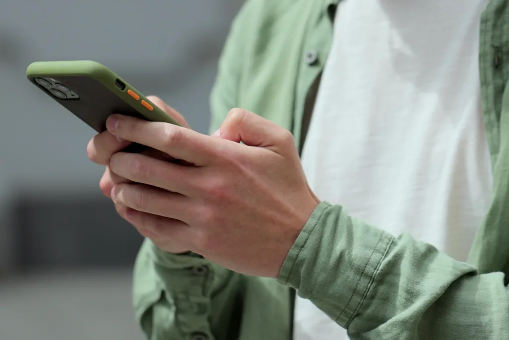Persona usando celular para solicitar examen ocupacional en Forjar Salud.