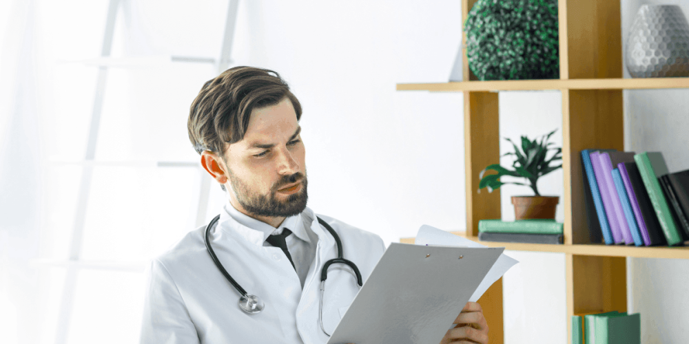 Médico revisando historia clínica durante examen ocupacional según la Resolución 1843 de 2025
