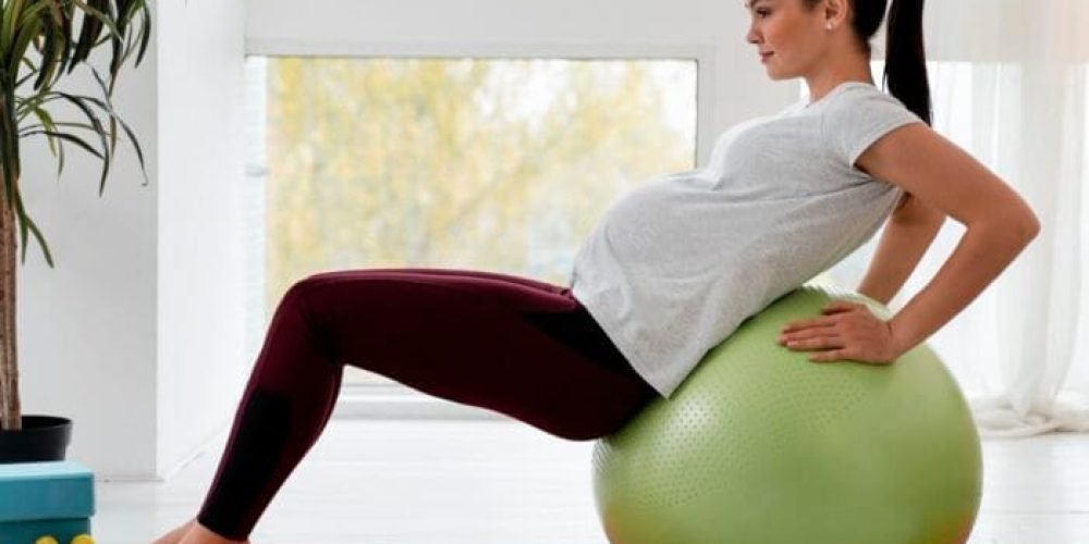 vista-lateral-joven-embarazada-haciendo-ejercicio-pelota-fitness Fisioterapia en gestación